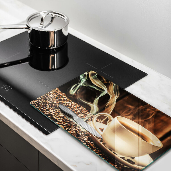 Tábua de corte de vidro Uma xícara e grãos de café