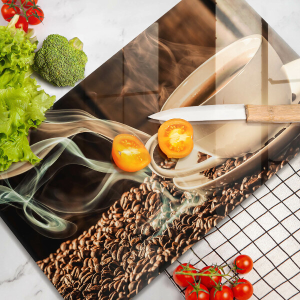 Tábua de corte de vidro Uma xícara e grãos de café